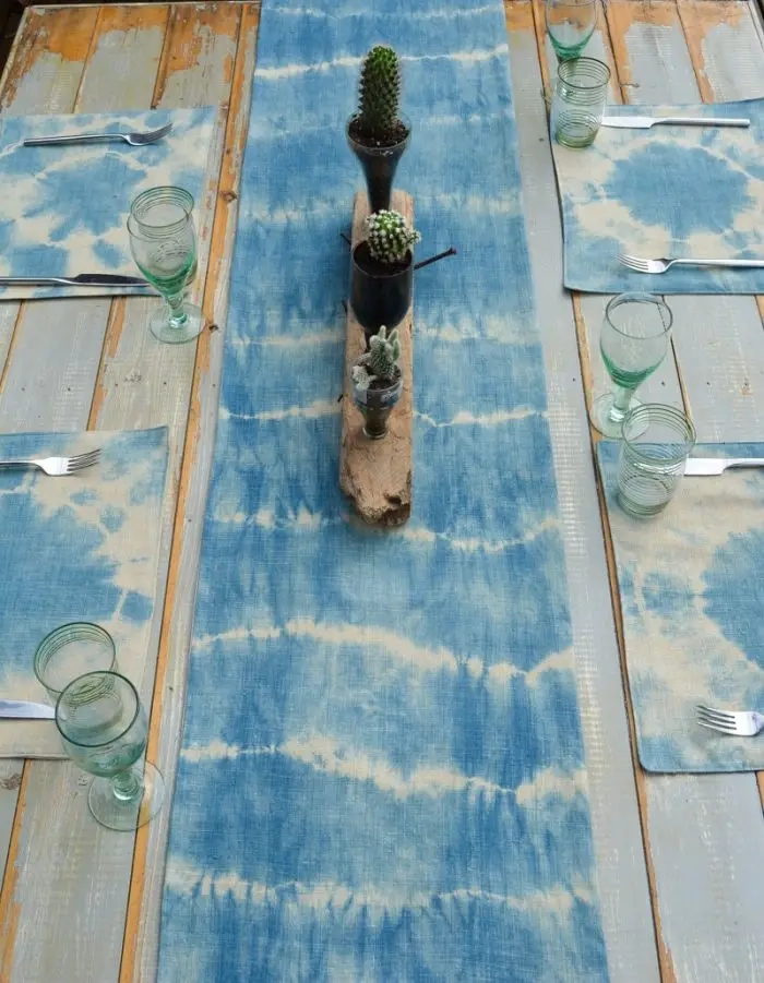Learn how to make a super easy fabric table runner. The tutorial includes video which shows you how to fold the fabric for this DIY Shibori table runner and table mats #fabrictablerunner