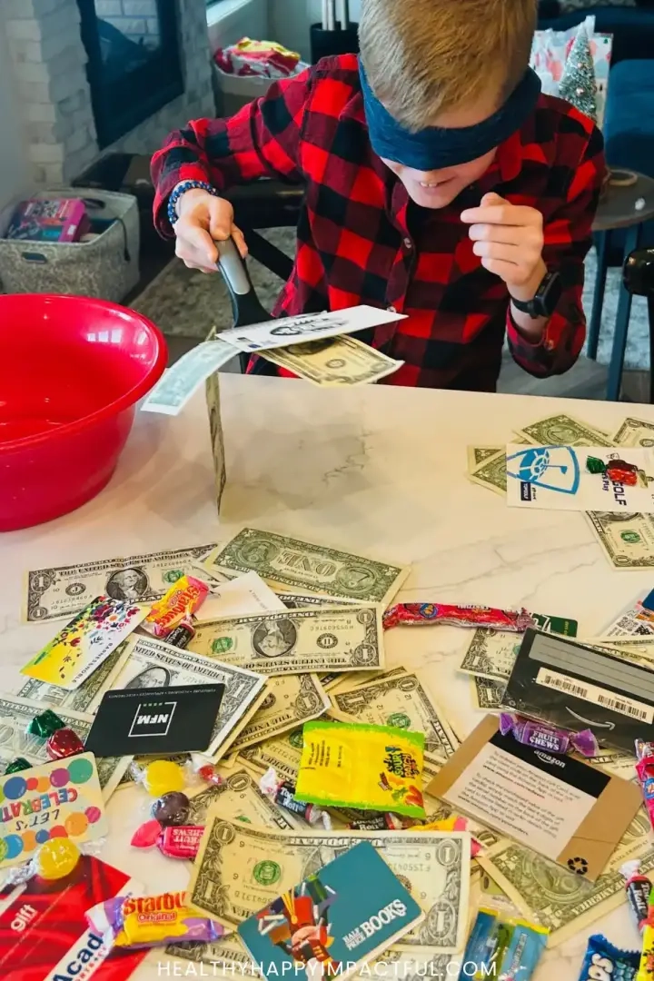 jongen die een geldspatel en cadeaukaartspel speelt met Kerstmis